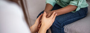 African psychologist hold hands of girl patient, close up.