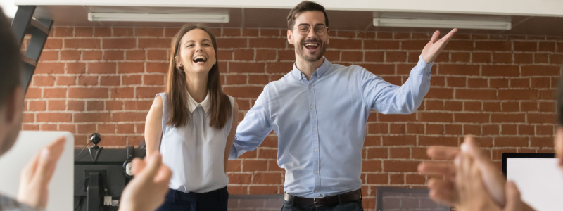 Excited company boss or team leader introducing new employee to colleagues in office welcoming hired newcomer member congratulating with promotion applauding celebrating reward, supporting coworker